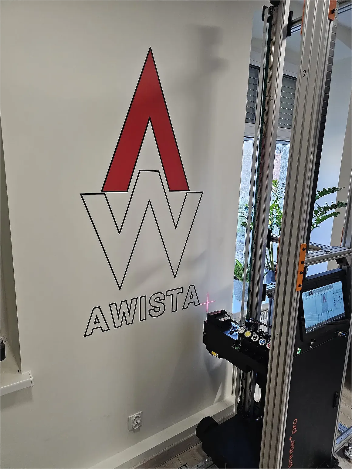 Logo firmy AWISTA wydrukowane na ścianie biura